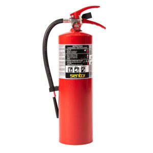 Extintor rojo Sentry con manija negra, boquilla e instrucciones visibles.